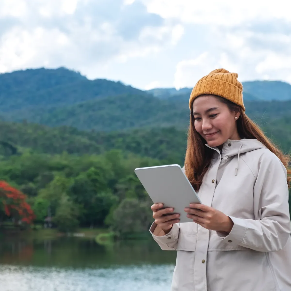 Nainen käyttää tablettia ulkona.