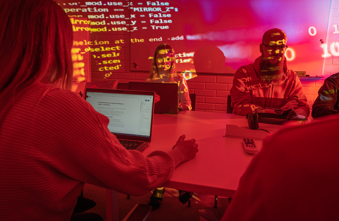 Hurjan työntekijöitä toimistolla pöydän ääressä.