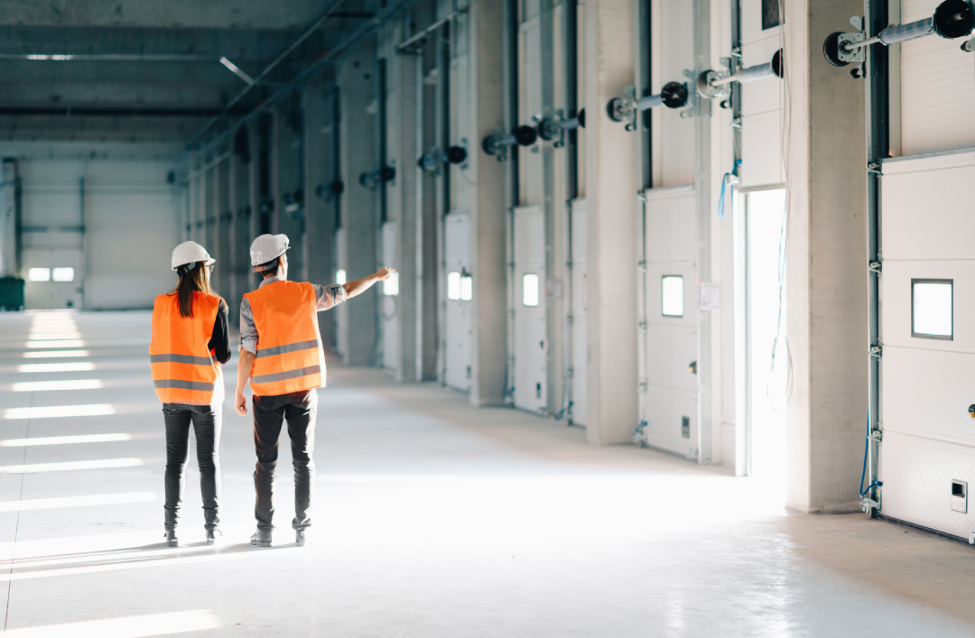 Älykäs etähallinta teollisuudessa blogin artikkelikuva, jossa kaksi kunnossapitoinsinööriä seisoo teollisuushallissa.