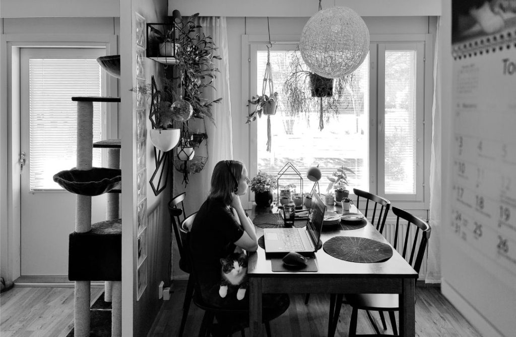 Hybridityö tapahtuu kotona ja toimistolla. Kuvassa työntekijä etätöissä keittiössä.